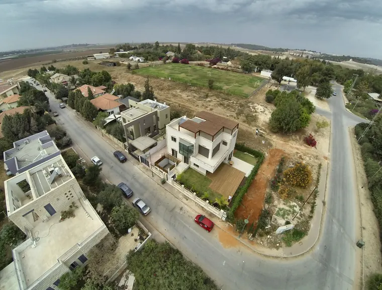 הבית בתוך שכונת ההרחבה, עם השדות הפתוחים ברקע